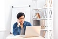 Businessman using laptop and talking on cell phone in office Royalty Free Stock Photo