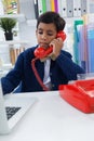 Businessman using laptop while talking on landline phone Royalty Free Stock Photo