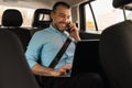 Businessman using laptop talking on smartphone while going by car Royalty Free Stock Photo