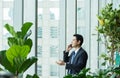 Businessman using mobile phone near office window at receptions Royalty Free Stock Photo