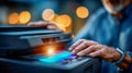 Businessman using a multifunction laser printer at night, tapping on the touchscreen panel in an office environment Royalty Free Stock Photo