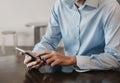 Businessman using smart phone for mobile payments online shopping, omni channel, sitting on table Royalty Free Stock Photo