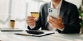 Businessman using smart phone for mobile payments online shopping,omni channel,sitting on table,virtual icons graphics interface Royalty Free Stock Photo