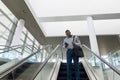 Businessman using smartphone on escalator Royalty Free Stock Photo