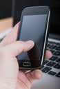 Businessman using smartphone on laptop background Royalty Free Stock Photo