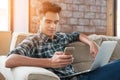 Businessman using smartphone and laptop writing on sofa Royalty Free Stock Photo