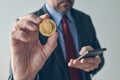 Businessman using smartphone to trade Ethereum cryptocurrency, digital mobile e-wallet concept