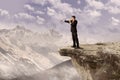 Businessman using speaker on cliff Royalty Free Stock Photo