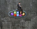 Businessman using tablet on black cloud with app icons Royalty Free Stock Photo