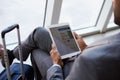 Businessman Viewing Boarding Pass In Airport Lounge