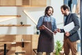 smiling bearded businessman and waiter standing and talking Royalty Free Stock Photo