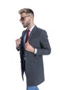 Businessman walking while arranging his coat and wearing sunglasses Royalty Free Stock Photo