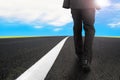 Businessman walking on asphalt road with sunlight blue sky