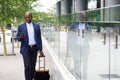 Businessman walking with bag and looking at mobile phone Royalty Free Stock Photo