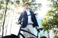 Businessman walking with bike in street after work. Royalty Free Stock Photo