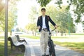 Businessman walking with bike in street after work. Royalty Free Stock Photo