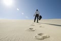 Businessman Walking With Briefcase In Desert Royalty Free Stock Photo