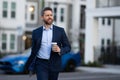 Businessman walking in city. Gray hair business man walk on city street. Business man walking outdoor, hold take away Royalty Free Stock Photo