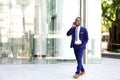 Businessman walking in the city using mobile phone Royalty Free Stock Photo