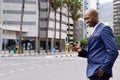 Businessman walking in the city and using mobile phone Royalty Free Stock Photo