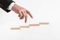 Businessman walking his fingers up steps formed by wooden blocks Royalty Free Stock Photo