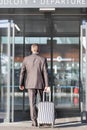 Businessman walking with his luggage in departure area at airport Royalty Free Stock Photo