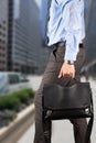 Businessman walking and holding a leather briefcase in his han Royalty Free Stock Photo