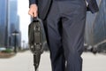 Businessman walking and holding a leather briefcase in his han Royalty Free Stock Photo