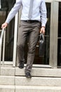 Businessman walking out from the office after working day and holding a leather briefcase in his hand Royalty Free Stock Photo