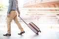 Businessman walking outside public transport building with luggage in rush hour. Business traveler pulling suitcase in modern airp Royalty Free Stock Photo