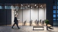 Businessman walking past evening business center with spacious conference room