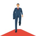 Businessman walking on a red carpet.