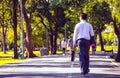 Businessman walking on road in park. Royalty Free Stock Photo