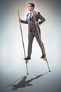 The businessman walking on stilts - standing out from the crowd Royalty Free Stock Photo