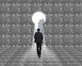 Businessman walking toward key shape door with puzzles background