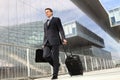 Businessman walking with trolley and bag Royalty Free Stock Photo