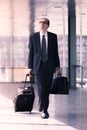 Businessman walking with trolley and briefcase Royalty Free Stock Photo