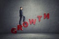 Businessman walking up ladder made of letters that arrange 'growth' word