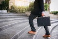 Businessman walking up the stairs and holding a briefcase in han Royalty Free Stock Photo