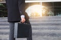 Businessman walking up the stairs and holding a briefcase in han Royalty Free Stock Photo