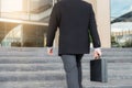 Businessman walking up the stairs and holding a briefcase in han Royalty Free Stock Photo