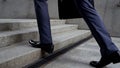 Businessman walking up stairs, success in career concept, promotion, closeup