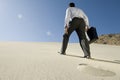 Businessman Walking Uphill In Desert Royalty Free Stock Photo