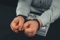 The businessman was caught stealing money and handcuffed. The hands of a businessman in handcuffs lie on a pile of Royalty Free Stock Photo
