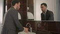 Businessman washing face in bathroom