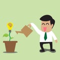 Businessman watering a light bulb idea plant