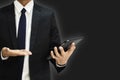 Businessman wearing a black suit holding digital tablet in back background smart connection network information. Royalty Free Stock Photo
