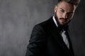 Businessman wearing black tuxedo posing cool looking away