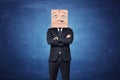 Businessman is wearing cardboard box on his head with painted disappointed face Royalty Free Stock Photo