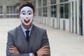 Businessman wearing a disturbing mask with arms crossed
